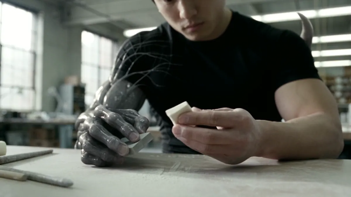 A forearm covered in the organism working at a desk
