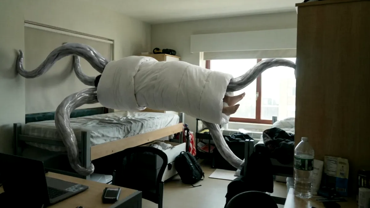 Thin grey tentacles moving through a dorm room