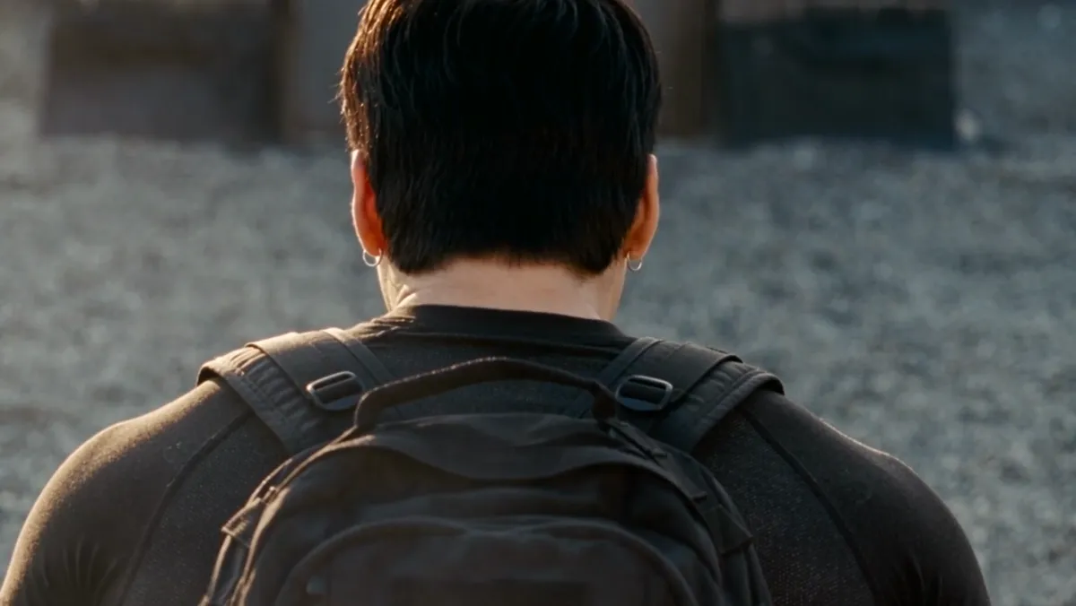 The back of a head and a backpack on a rooftop