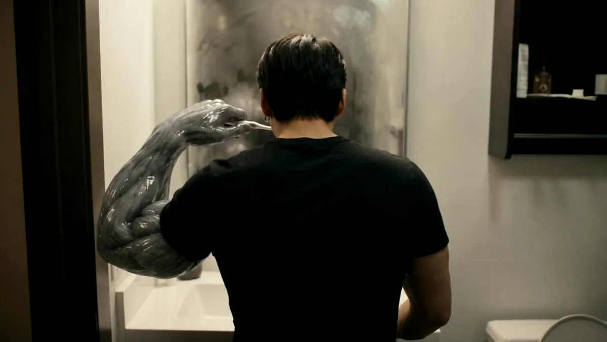 Seen from behind in a dorm room, one arm covered in the organism