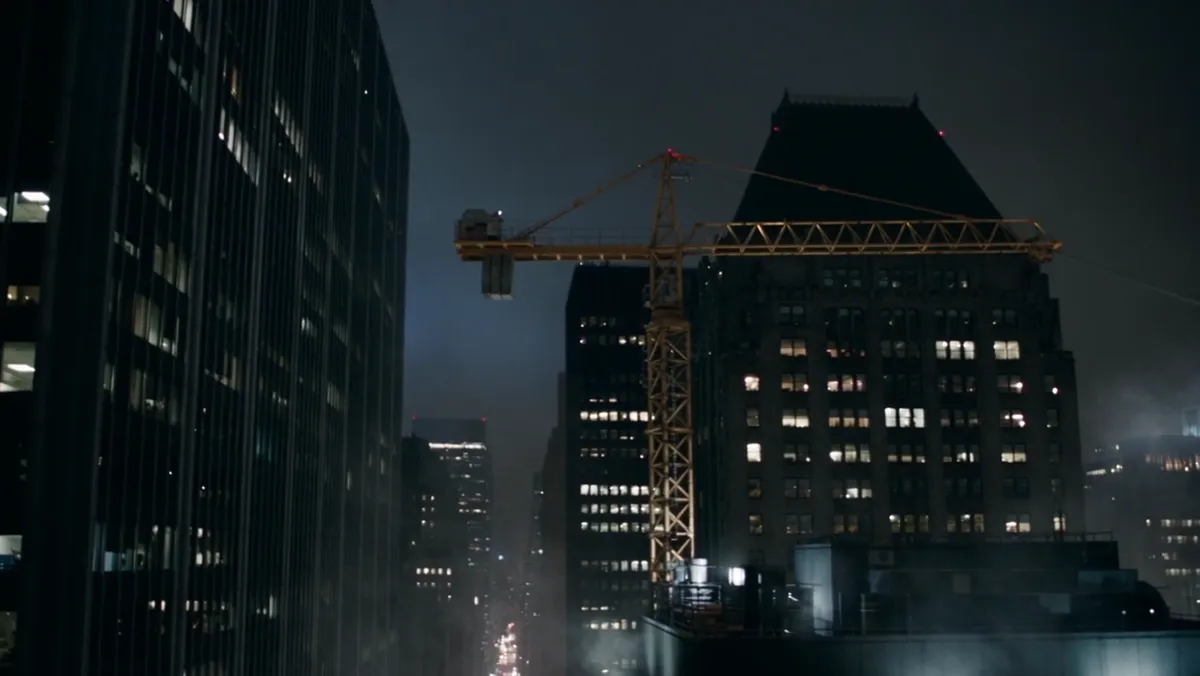 Midtown towers at night with a figure swinging between them