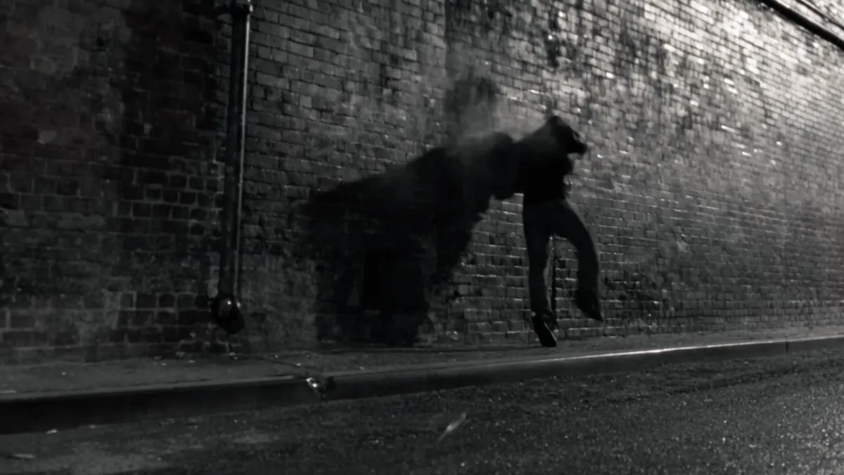 A man thrown back against a brick wall