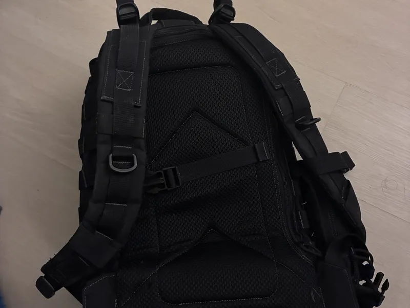 A black backpack lying on a floor