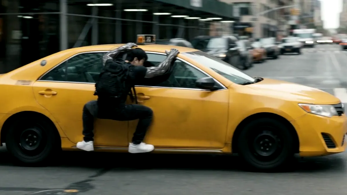 Sitting on the side of a moving yellow taxi